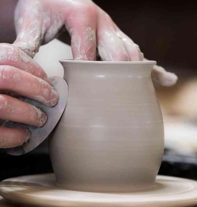 A pair of hands shaping a ceramic item